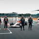 At first I assumed it began to drizzle right as this photo was taken, which would’ve explained why almost every driver is looking toward the sky. Turns out, there was another camera up there. Still, Lewis doesn’t seem to care, and George is totally loving the moment.